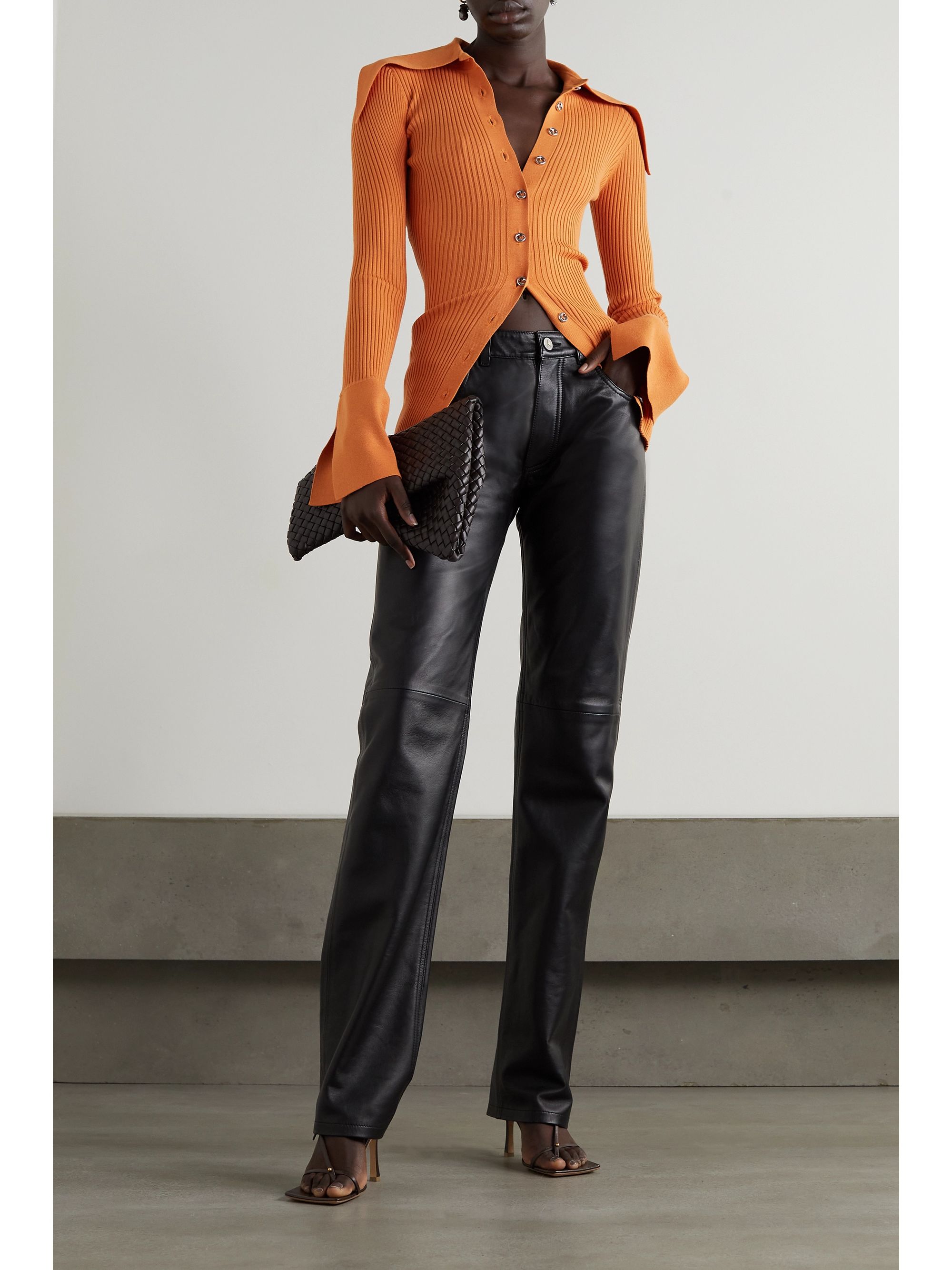 16ARLINGTON Liyu ribbed-knit orange cardigan. It comes in a rib knit that hugs the body and has an exaggerated collar and sleeve detail. It fastens up the center with gold buttons. 