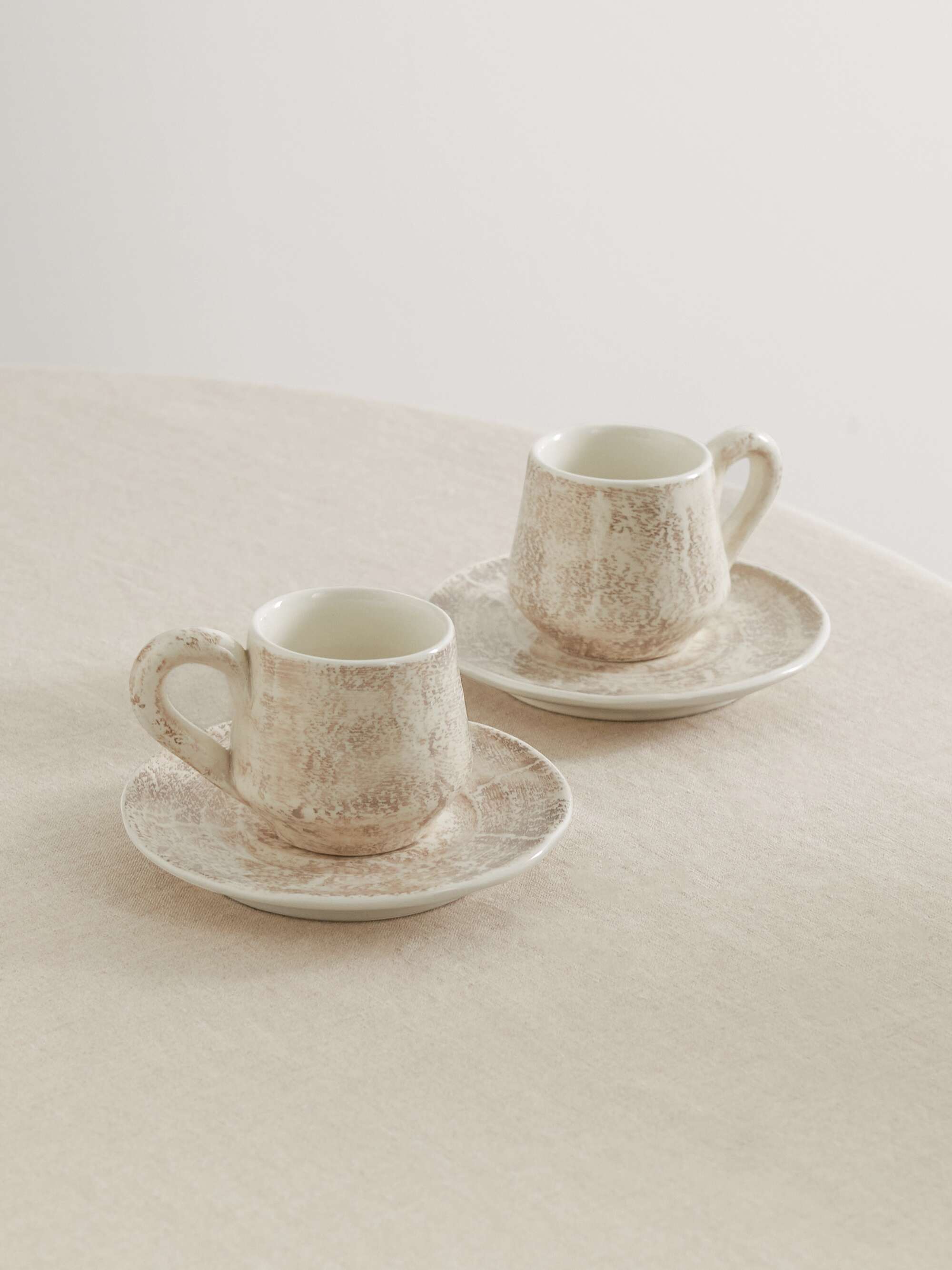 Set of two glazed ceramic mugs and saucers