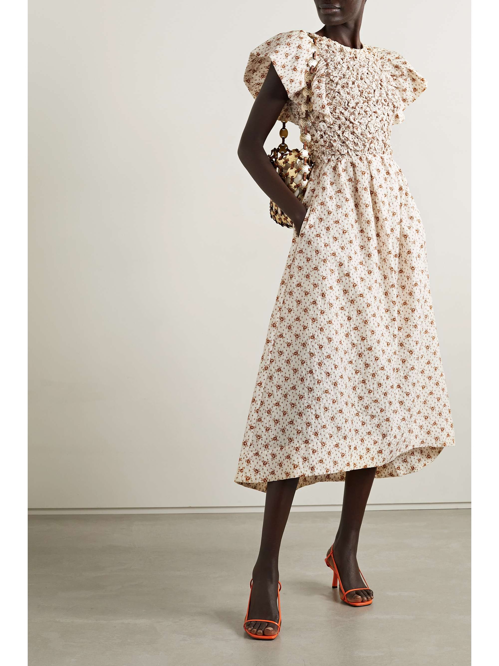 Sea Wilma dress comes in a floaty silhouette and is cut from cream matelassé cotton-blend with a smocked bodice framed by fluttery sleeves. It has a  delicate vintage feel floral print. The back features an open back with smocked straps across. 