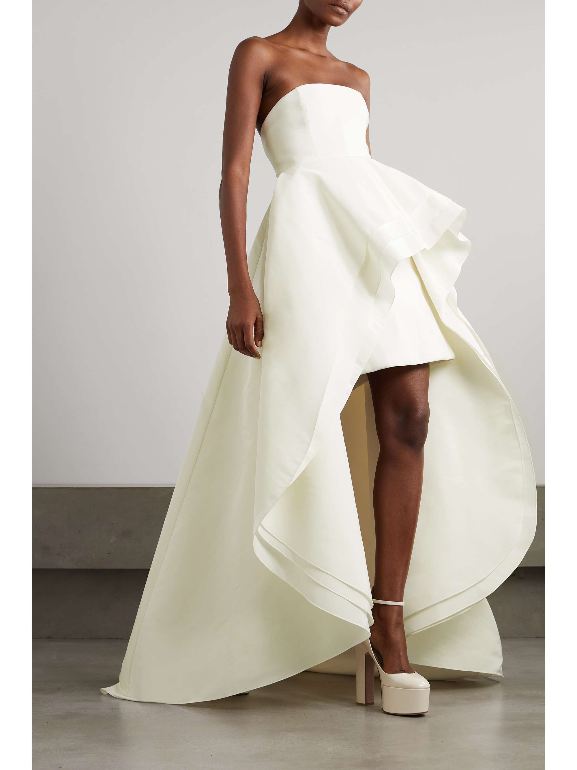 EXCLUSIVE AT NET-A-PORTER. Wes Gordon's creations for Carolina Herrera are all about celebrating the beauty of the moment – what could be better for your big day? Tiered from swathes of silk-faille, this gown has a billowing high-low hem, perfect for showing off an extra special pair of shoes. The strapless neckline will look just as beautiful with a delicate necklace as it will a sweep of highlighter across your décolletage.
