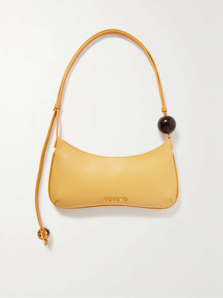 wedding guest accessories to elevate your 2023 wedding guest outfit. The curved shape of Jacquemus' 'Le Bisou Perle' bag is timelessly elegant. Crafted from supple leather, it's embellished with spheres poised at either end of the sleek shoulder strap. The golden hardware is polished for subtle sparkle.