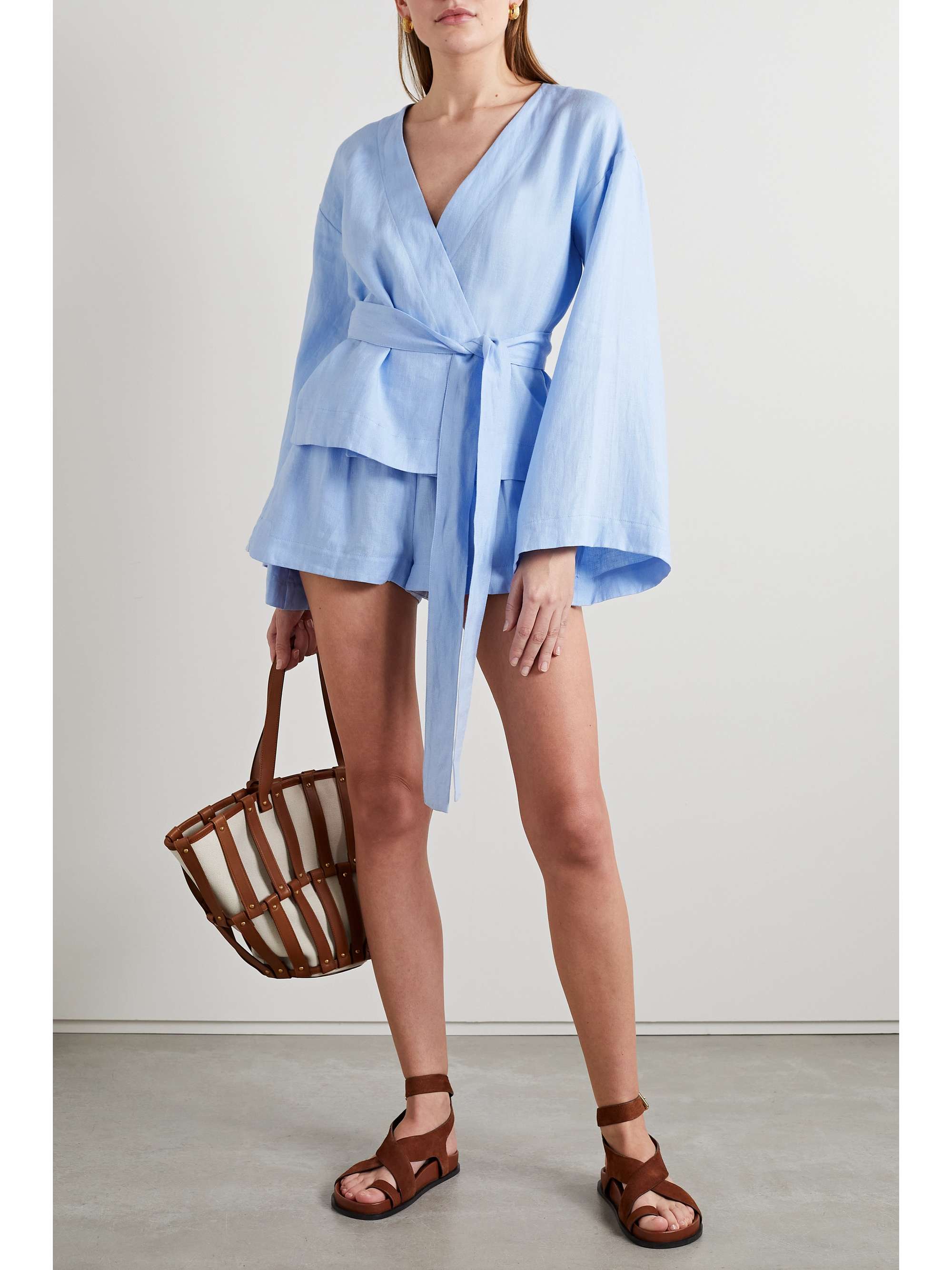 BONDI BORN's 'Paros' top is inspired by traditional Japanese kimono silhouettes. Made from airy sky-blue linen-voile, it has wide angular sleeves, a plunging V-neckline and dramatic waist-cinching belt. Wear yours with the coordinating shorts.