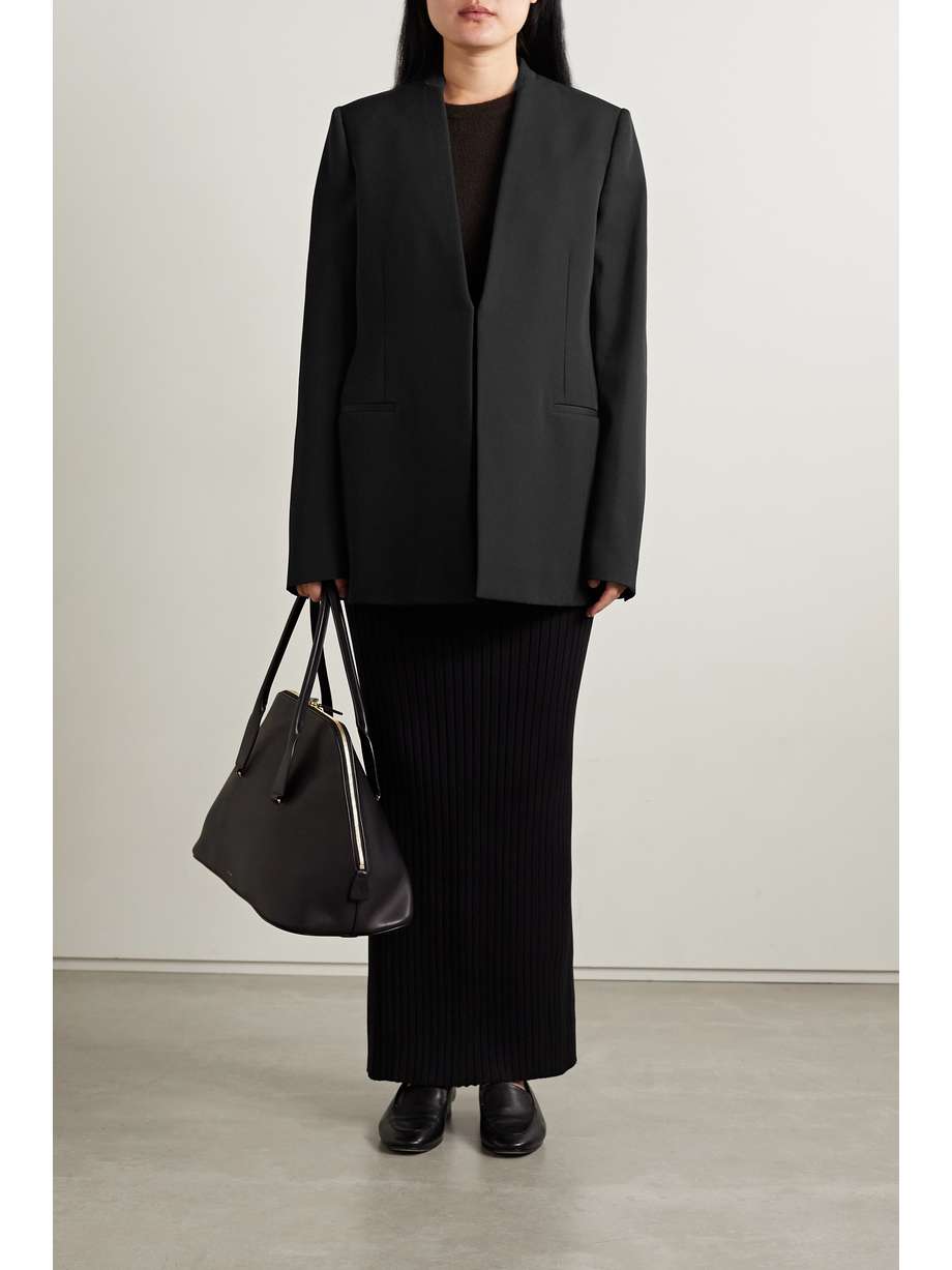 The Row's 'Bartholomew' blazer is minimally designed without traditional lapels. Tailored from wool for a loose fit, it has padded shoulders and a back vent. The silk lining ensures smooth, easy layering over a collared shirt or fine sweater.