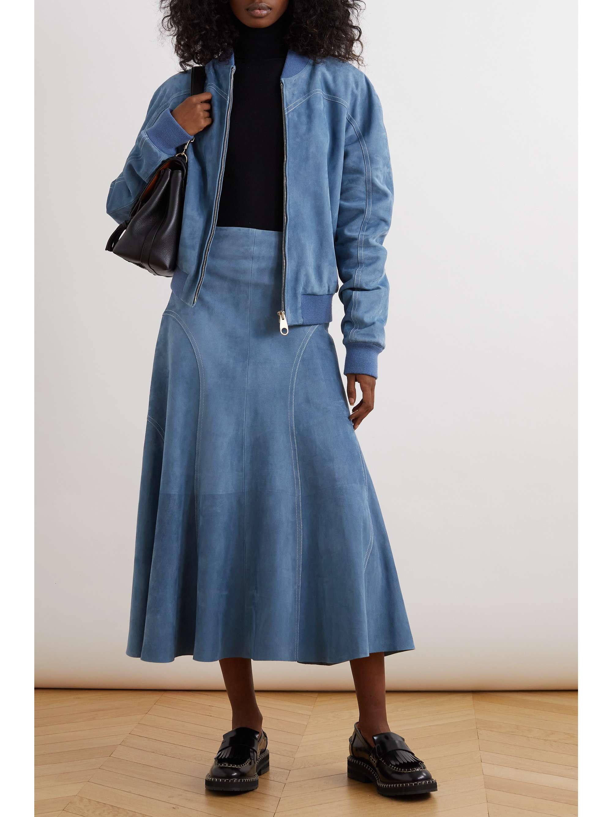 From afar, Chloé's skirt could easily be mistaken for denim, but it's actually made from soft suede. Reminiscent of '70s styles, it has topstitched panels at the sides and pleats that create beautiful movement. We have the matching jacket in our edit, too.