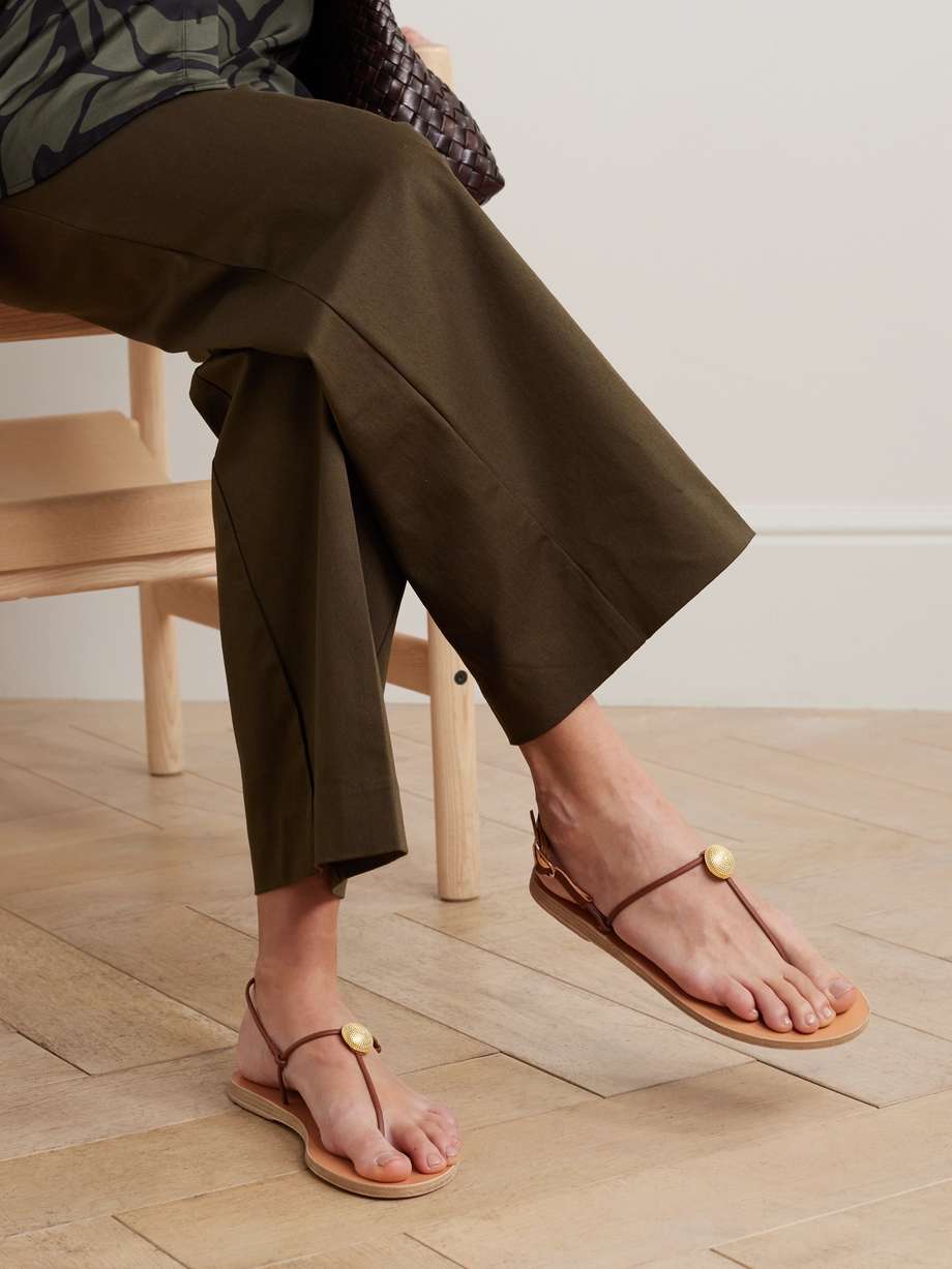 EXCLUSIVE AT NET-A-PORTER. When it comes to vacation outfit planning, Ancient Greek Sandals has your footwear covered. This 'Dimitria' pair is handmade with slim, rolled leather straps and features a gleaming gold-tone embellishments that complement the wing-shaped buckle.