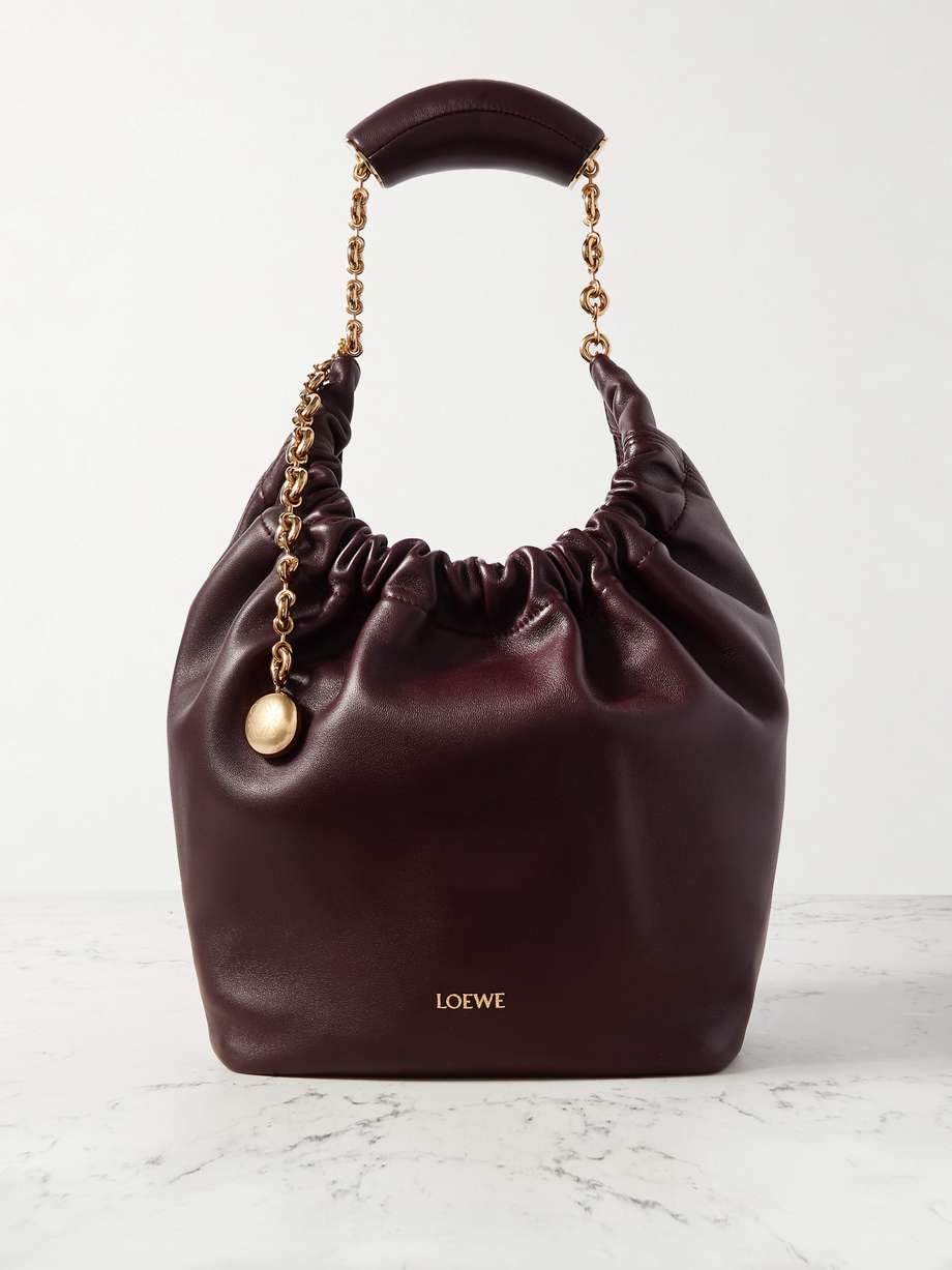 The bags debuted at Loewe's Fall '23 runway show were inspired by '70s styles from the brand's archives. Made from buttery soft leather, this small 'Squeeze' tote is ruched at the top and has a curved handle with a gold-tone chain. There's a zipped pocket inside for your phone or keys.