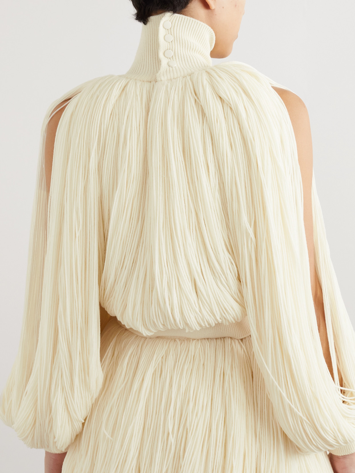 ALAÏA FRINGED WOOL-BLEND TURTLENECK TOP