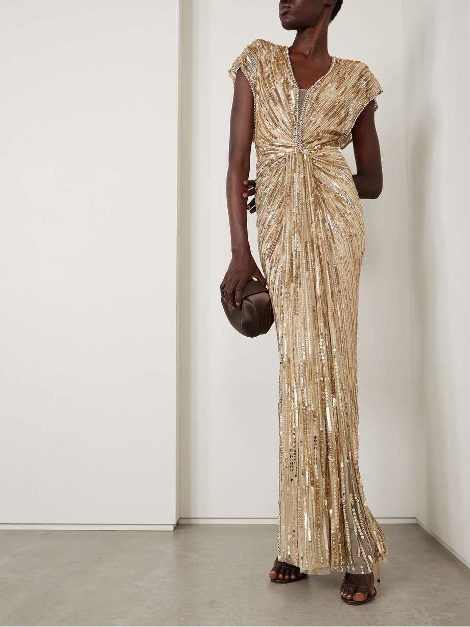 Jenny Packham Zola Draped Embellished Tulle Gown Jenny Packham Zola Draped Embellished Tulle Gown – Beige tulle gown with sequins, crystals, and beads; features a plunging neckline and padded shoulders.