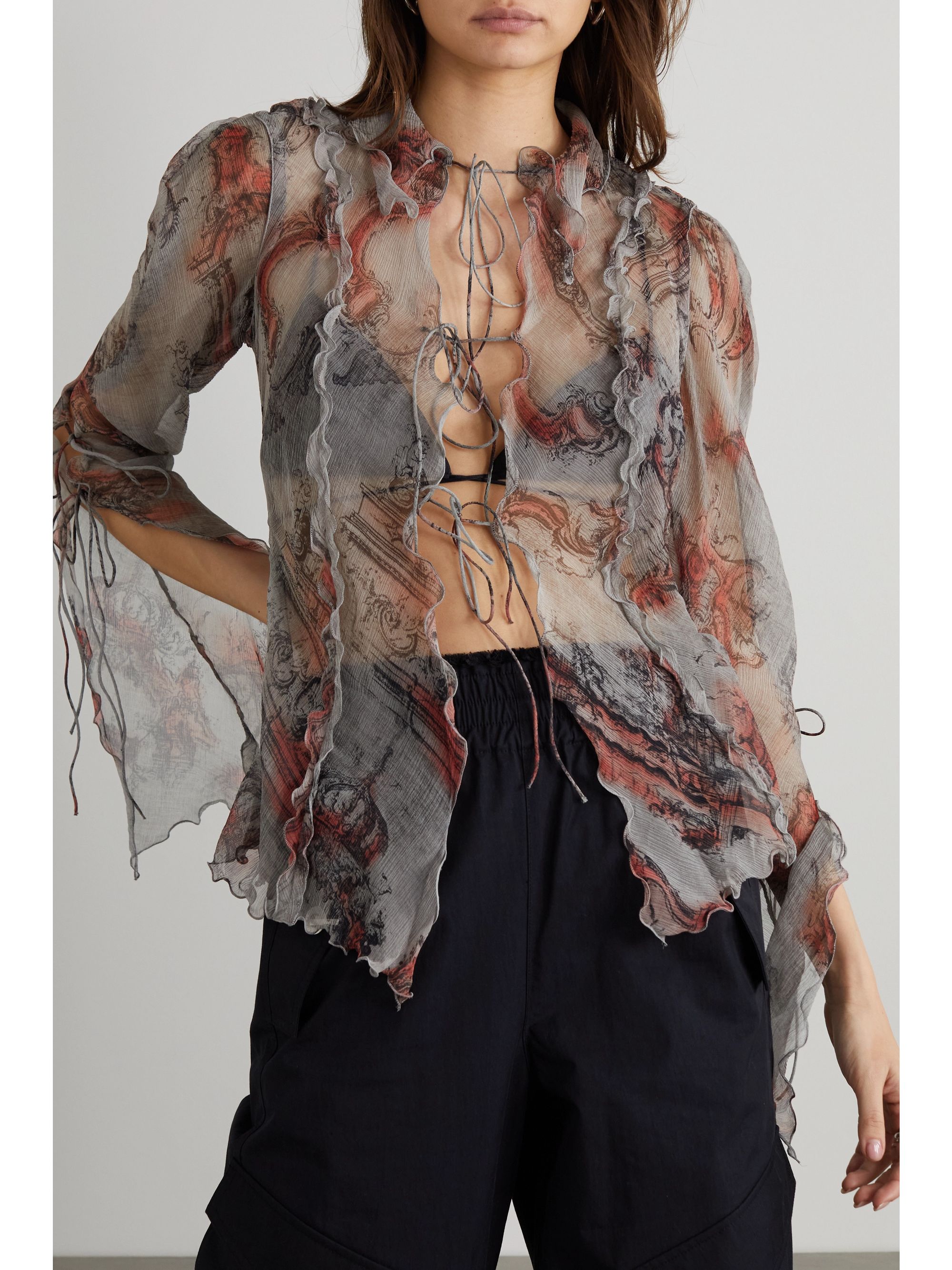 sheer tonal-gray and red silk-crepon tie front sheer blouse with ruffled edges and falls to a fluid drape. The wide collar and tie straps give it a slight '70s feel.